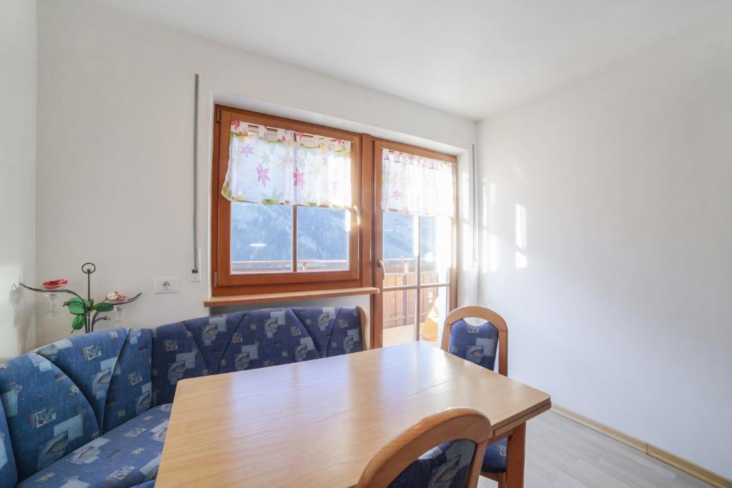 薩爾圖錫歐的住宿－Strickerhof - Appartment 3，一间带桌子和蓝色椅子的用餐室