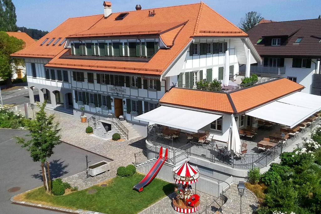 a large building with a red roof and a roller coaster at Gasthof zum Schlüssel in Ueberstorf