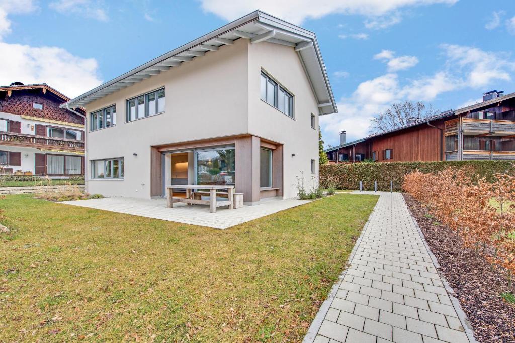 a white house with a picnic table on a lawn at Ferienhaus Seebruck in Seebruck