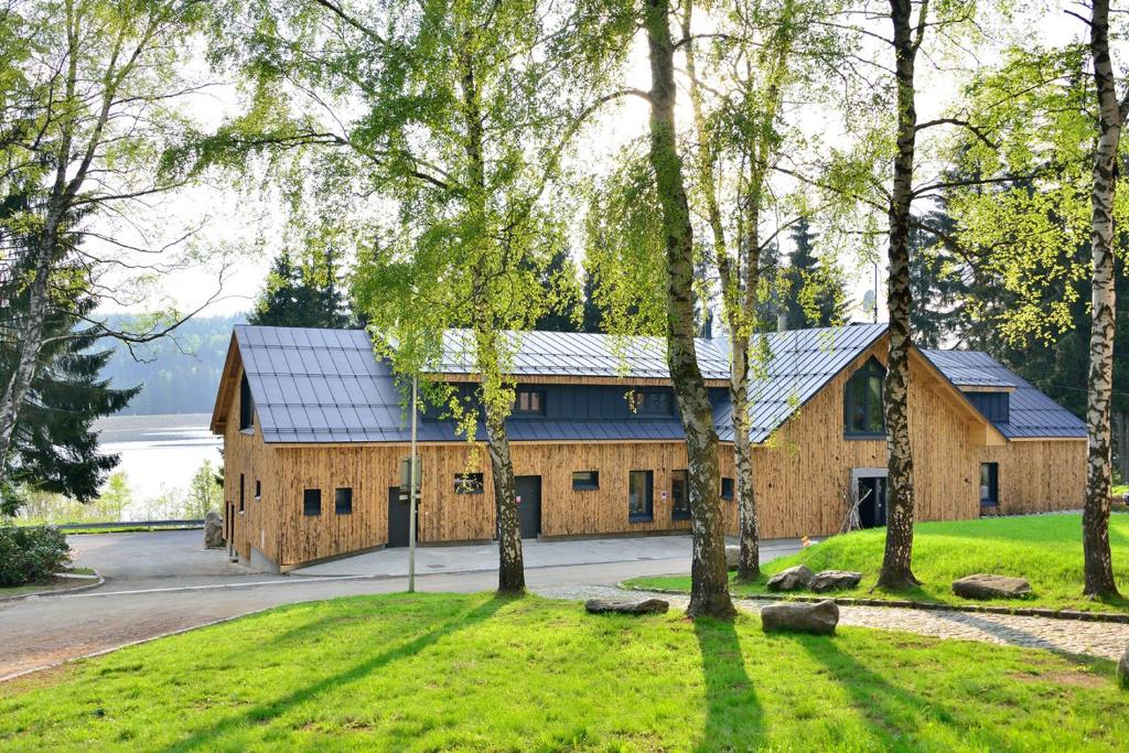 una casa con techo de metal y árboles en Montanie Resort en Desná