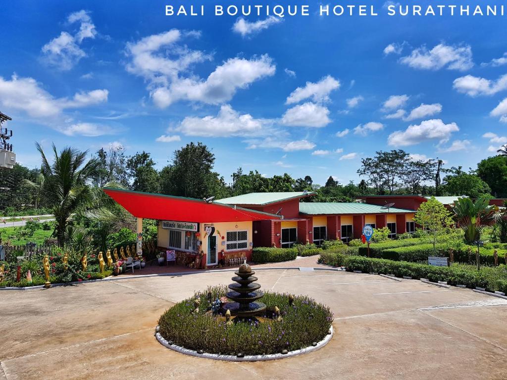 un hotel con techo rojo y un edificio en Bali Boutique Hotel Suratthani, en Suratthani
