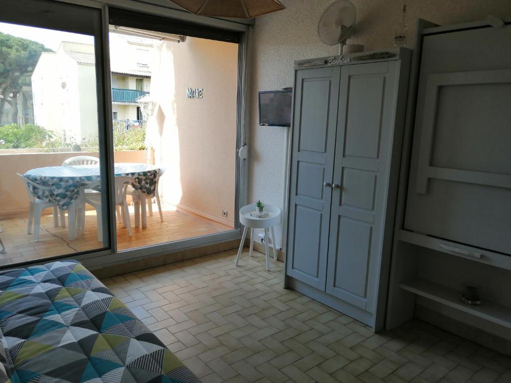 a room with a sliding door and a table and a television at La Calypso in Cavalaire-sur-Mer