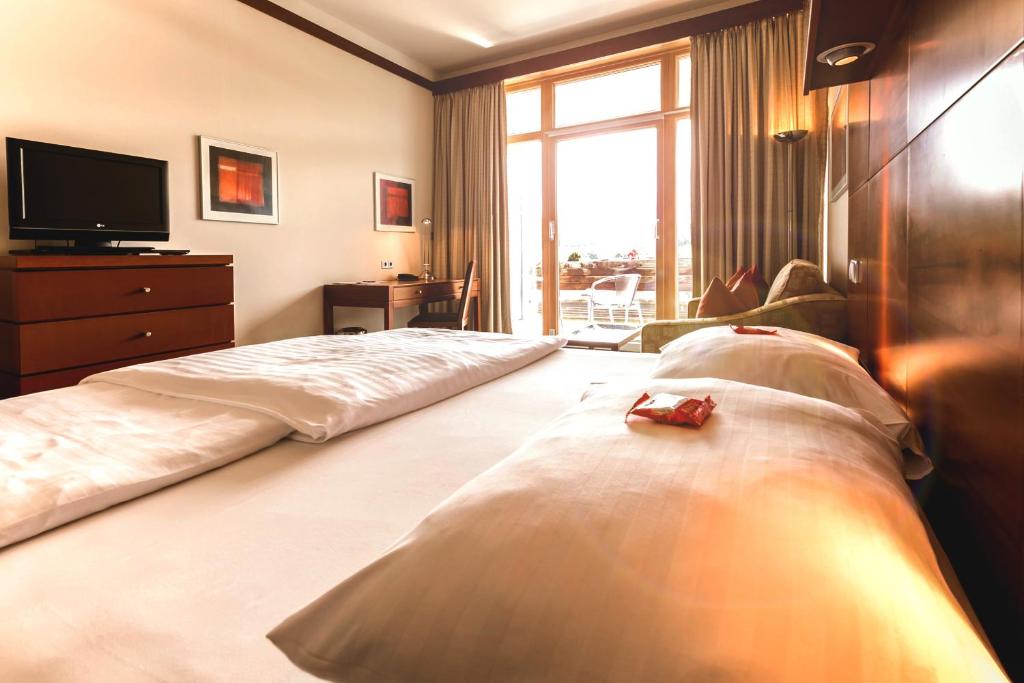 Postel nebo postele na pokoji v ubytování Das Sonnreich - Thermenhotel Loipersdorf