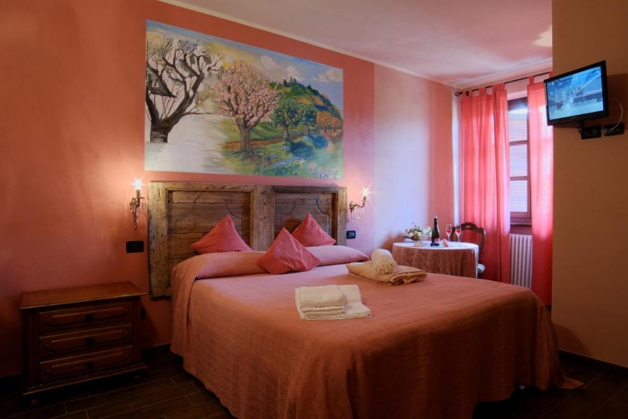 a bedroom with a large bed with a painting on the wall at Tre colline in langa in Bubbio