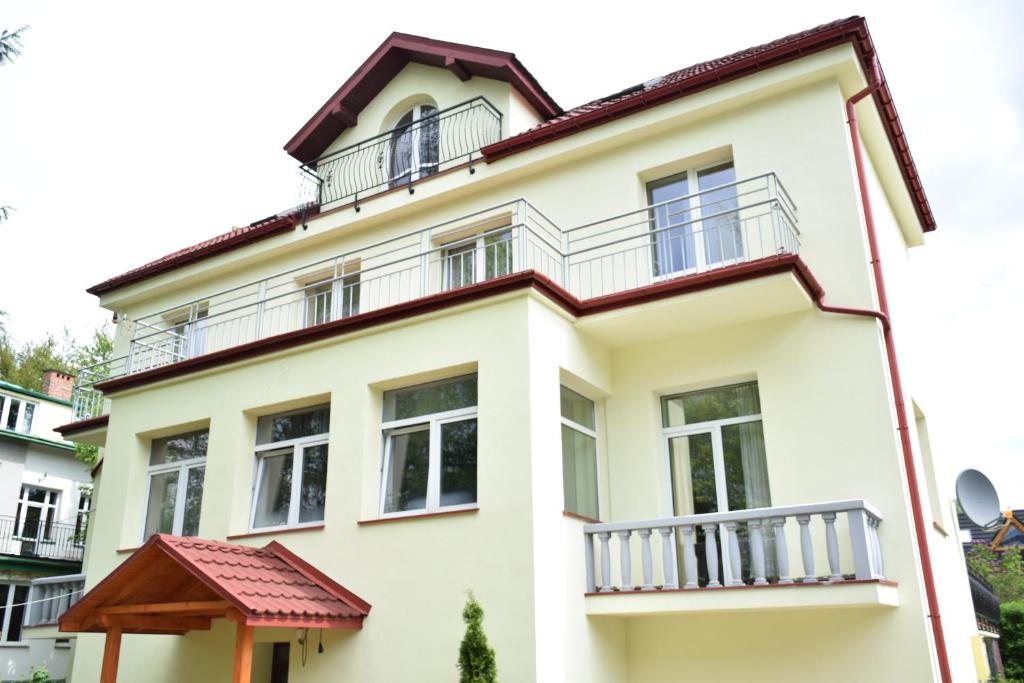 una casa blanca con balcones encima en Willa Zlocien en Zakopane