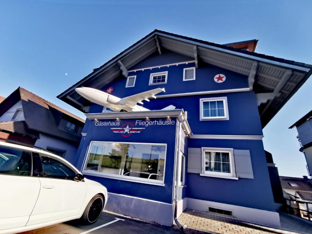 uma casa azul com um avião em cima dela em BnB Fliegerhaeusle Hagnau 24h Self Check In em Hagnau