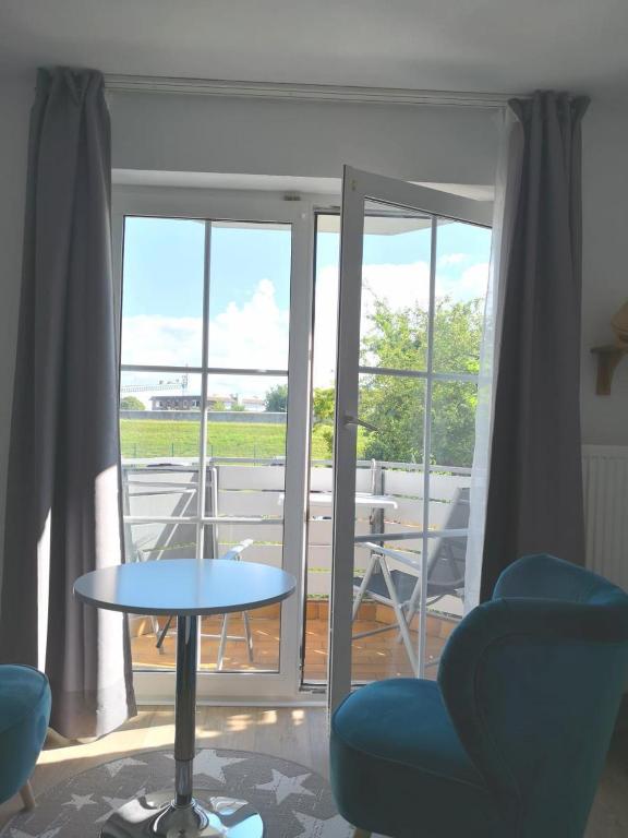 a room with a table and chairs and a balcony at Seeschloss 34 in Dahme