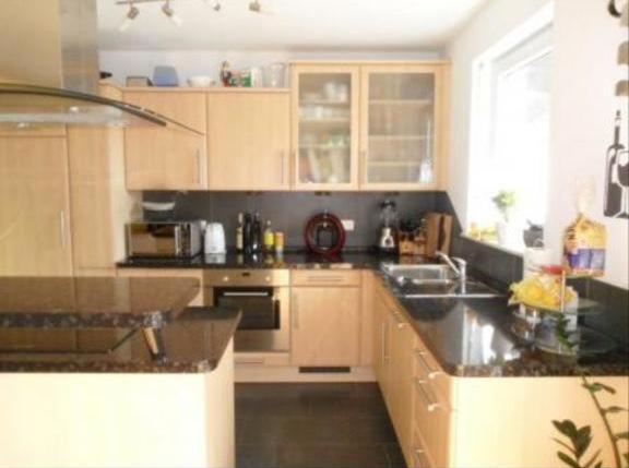 une cuisine avec des armoires en bois et un comptoir dans l'établissement Katjas Ferienwohnung, à Nittel
