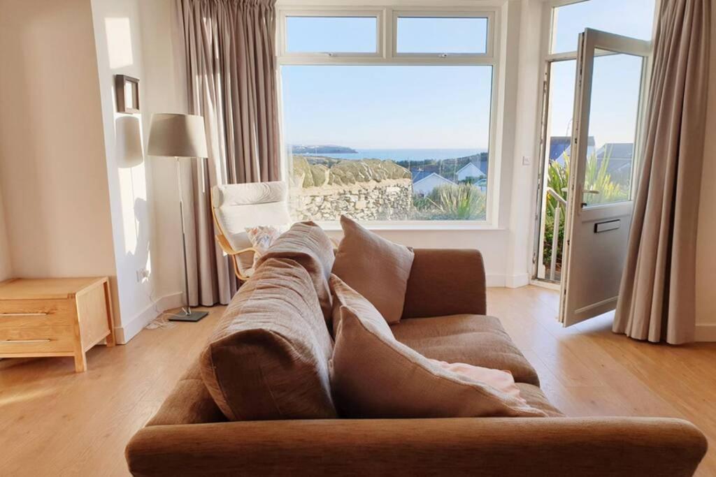 ein Wohnzimmer mit einem Sofa und einem großen Fenster in der Unterkunft 24 CLIFF APARTMENT-3 BED-GROUND FLOOR-SEA VIEWS in Trearddur