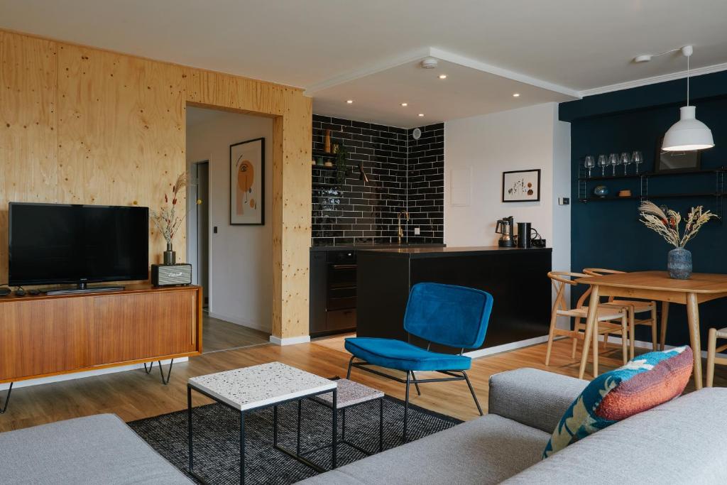 a living room with a couch and a tv and a table at Welcome in - Modernes Apartment 70-MA in der Nähe der Skipiste in Winterberg