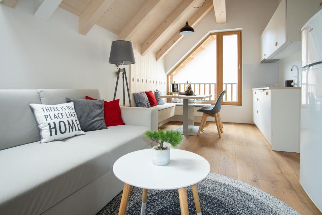 a living room with a white couch and a table at Apartment Špica - Private parking in Kranjska Gora