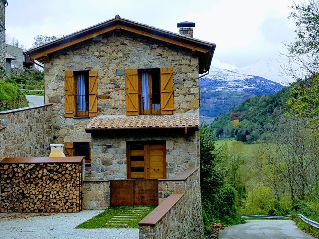 Casa de piedra con ventanas y vistas a las montañas en Casa de La Roca - Only Adults., en Vilallonga de Ter