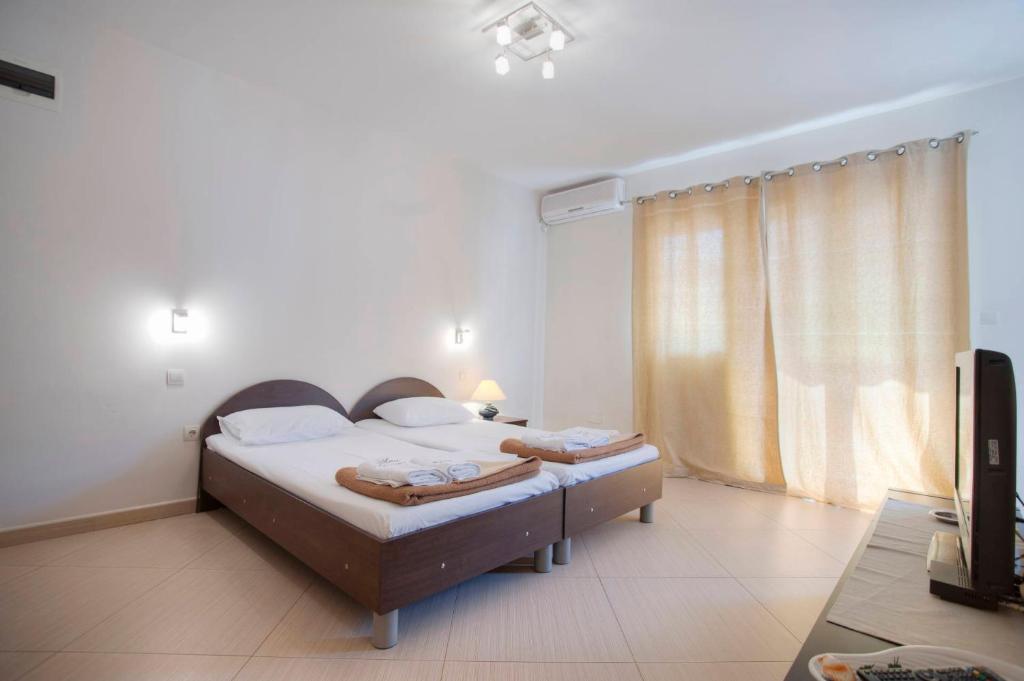 a bedroom with two beds and a television in it at Mandir apartments - Center in Budva