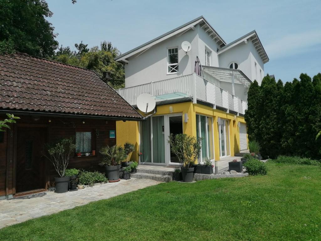 多瑙河畔伊布斯的住宿－伊布斯花園公寓，白色和黄色的房子,有院子