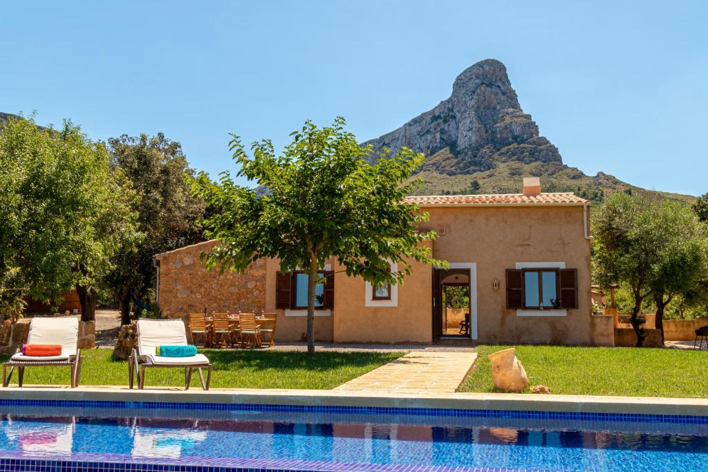 ein Haus und ein Pool mit einem Berg im Hintergrund in der Unterkunft Finca can Jaumi By homevillas360 in Artá