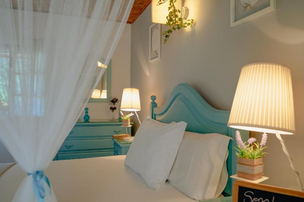 une chambre avec un lit avec une tête de lit bleue et deux lampes dans l'établissement TEA HOUSE GERÊS, à Gerês