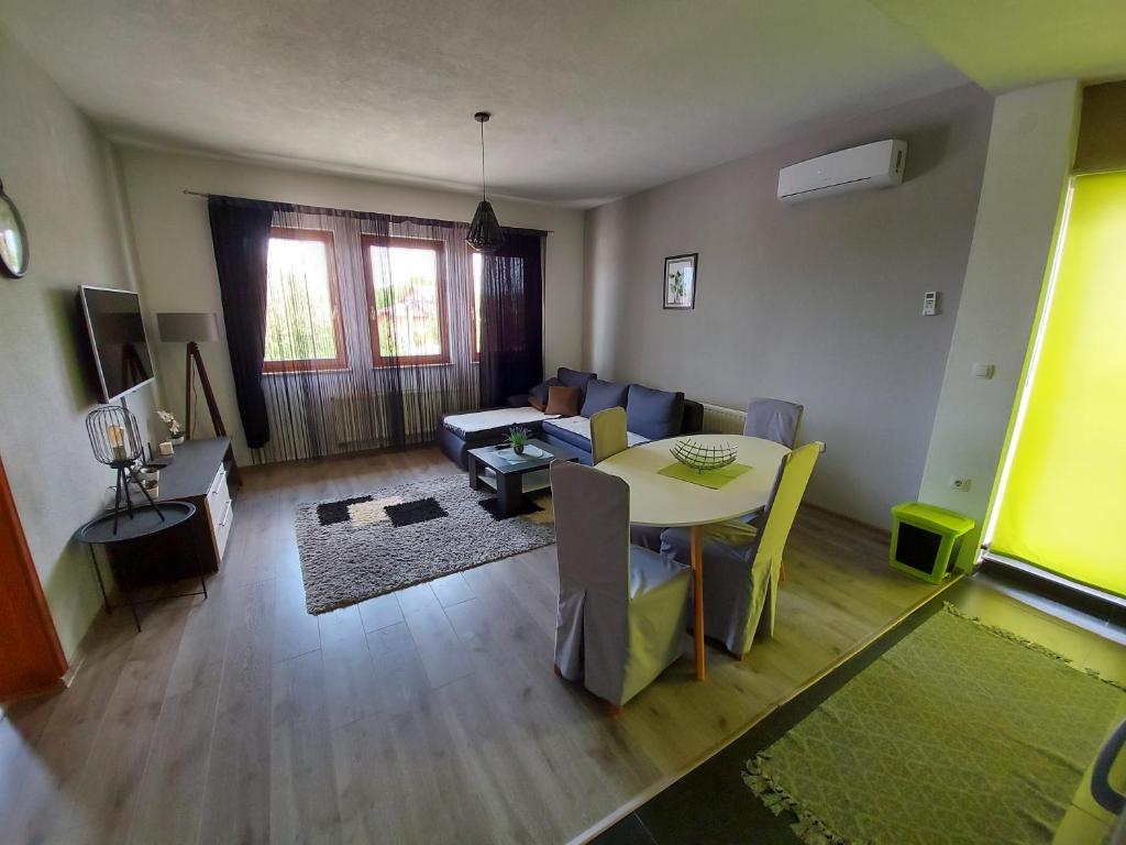 uma sala de estar com uma mesa e um sofá em Apartman Malkoc em Bihać