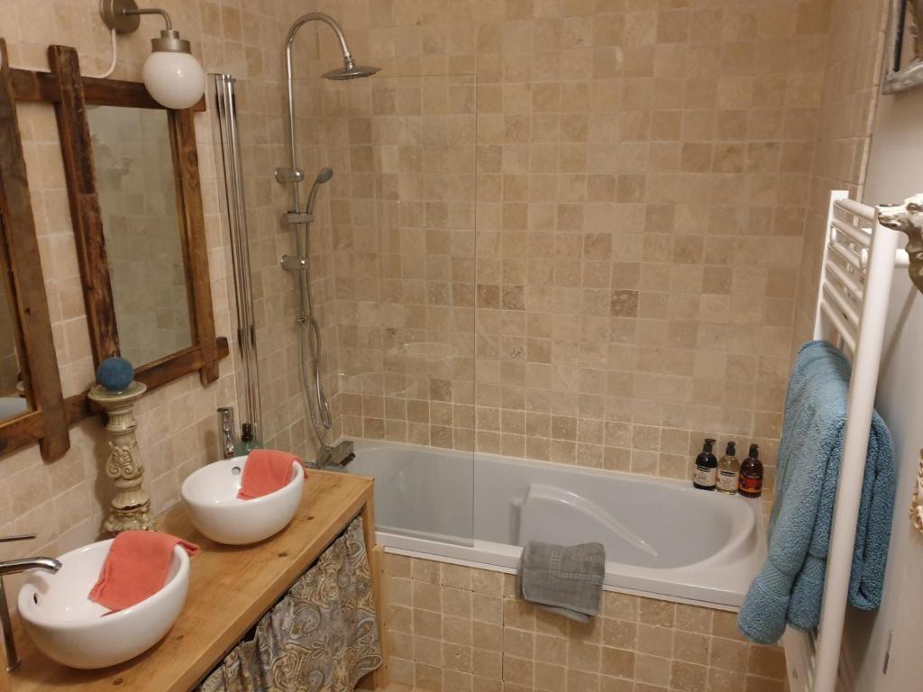 Saint-Gervais的住宿－le clos soleilhan，浴室配有盥洗盆和浴缸。