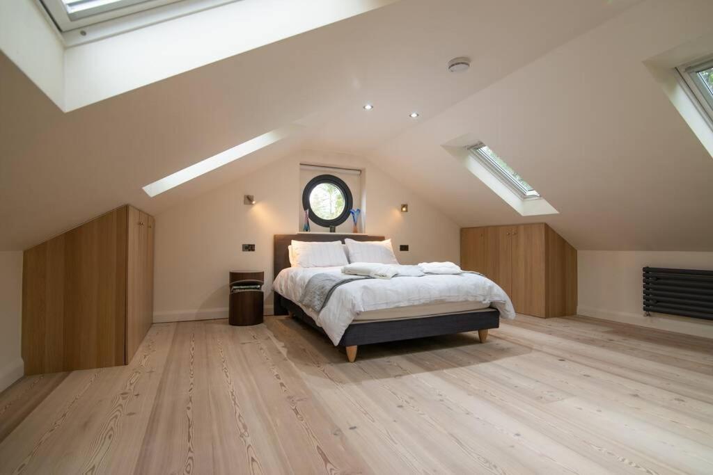 
a bedroom with a large bed and a large window at Luxury Coach house next to woodland in Knutsford in Knutsford
