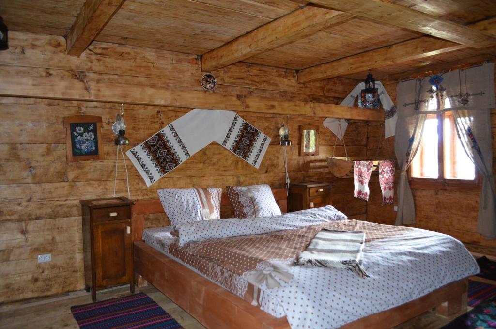 um quarto com uma cama num quarto com paredes de madeira em Гуцульська Спадщина em Vorokhta