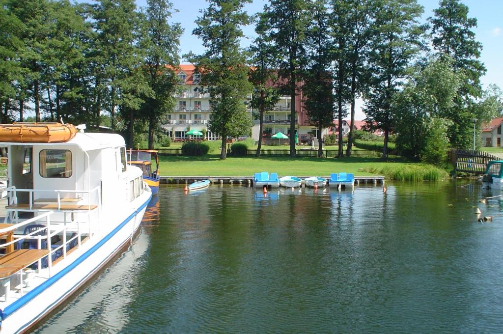 a boat docked at a dock in a river at Hotel Europa in Giżycko