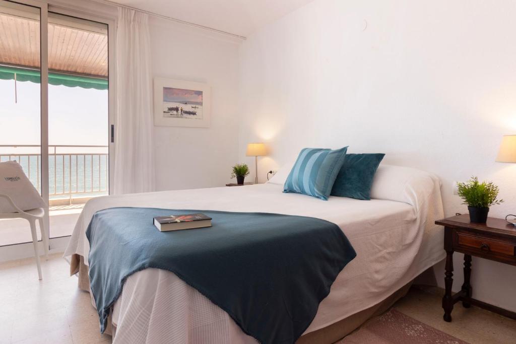 1 dormitorio blanco con 1 cama grande con almohadas azules en Homes & Go Bell Reco Confort II, en La Pineda