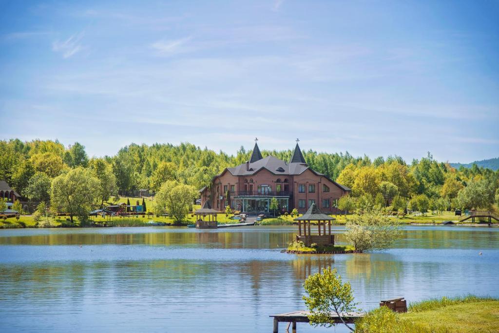a large house sitting on top of a lake at Shepilska Relax Complex in Dovholuka