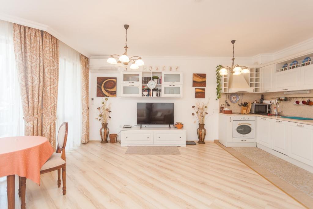 sala de estar amplia con mesa y TV en Dom-El Real Apartments Amphora, en Sveti Vlas