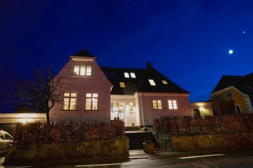 a couple of houses at night with the lights on at BnB Thuroe in Svendborg