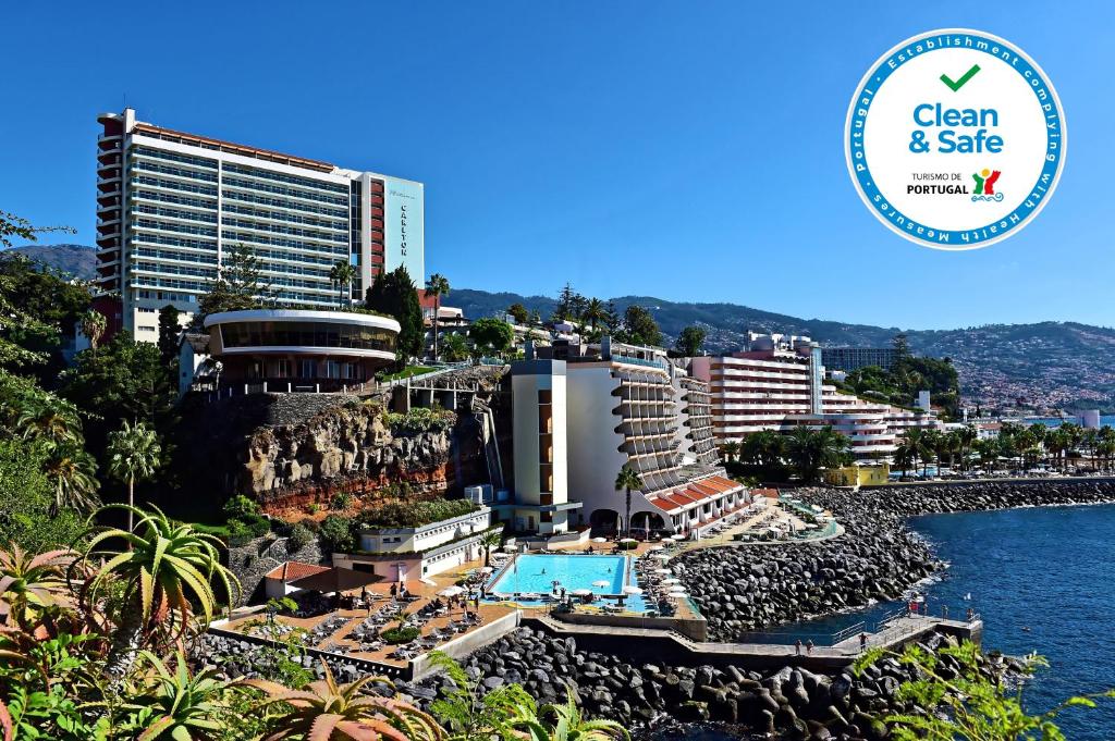 フンシャルにあるPestana Madeira Beach Clubのプールと建物のあるリゾートの景色を望めます。