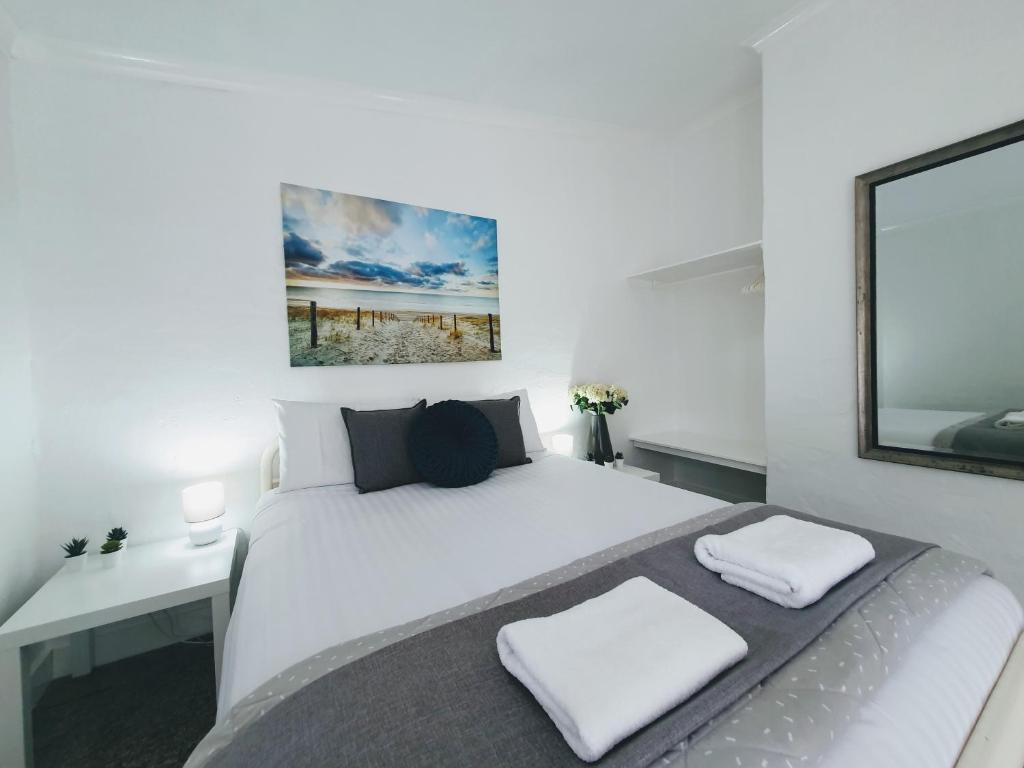 1 dormitorio con 1 cama blanca grande y 2 almohadas blancas en Busselton Holiday Units, en Busselton