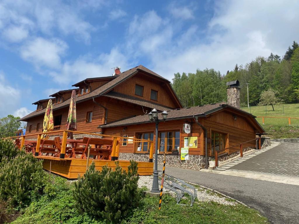 a large wooden building with a restaurant at Penzion U Pacošů in Malenovice