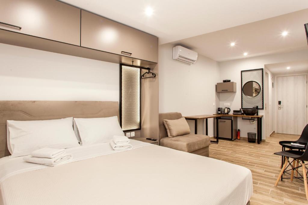 een slaapkamer met een groot wit bed en een stoel bij Raise The Heraklion Project in Heraklion