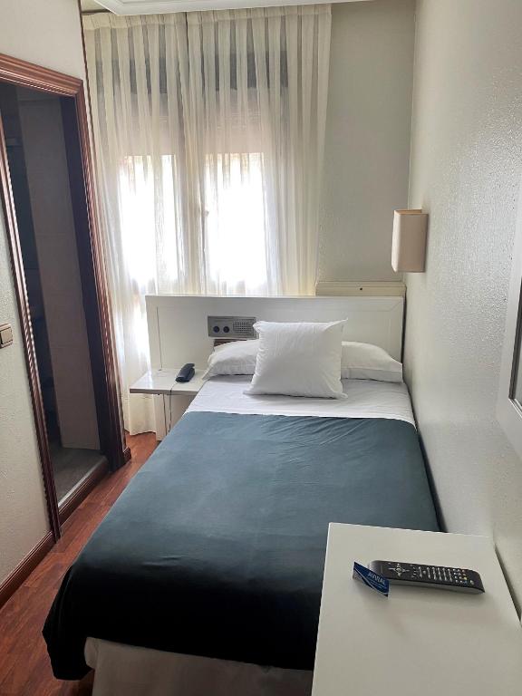 A bed or beds in a room at Hotel Ovetense