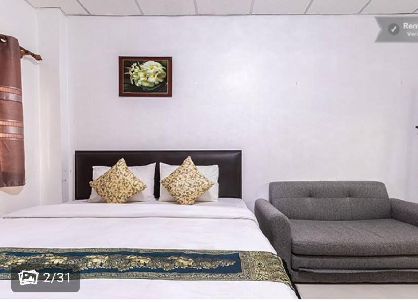 1 dormitorio con 1 cama y 1 silla en ลีลาวดีอพาร์ทเมนท์ en Khon Kaen