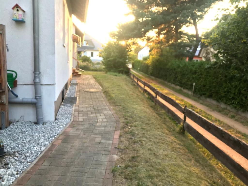 a brick path next to a house with a fence at Am Walde in Trassenheide