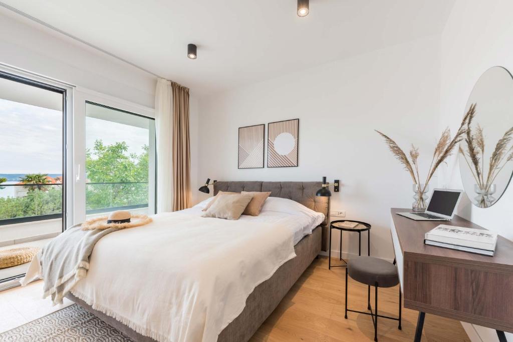 um quarto com uma cama, uma secretária e janelas em Villa Auni Perla - Heated Pool - Rooftop - Seaview - Beach em Kaštela