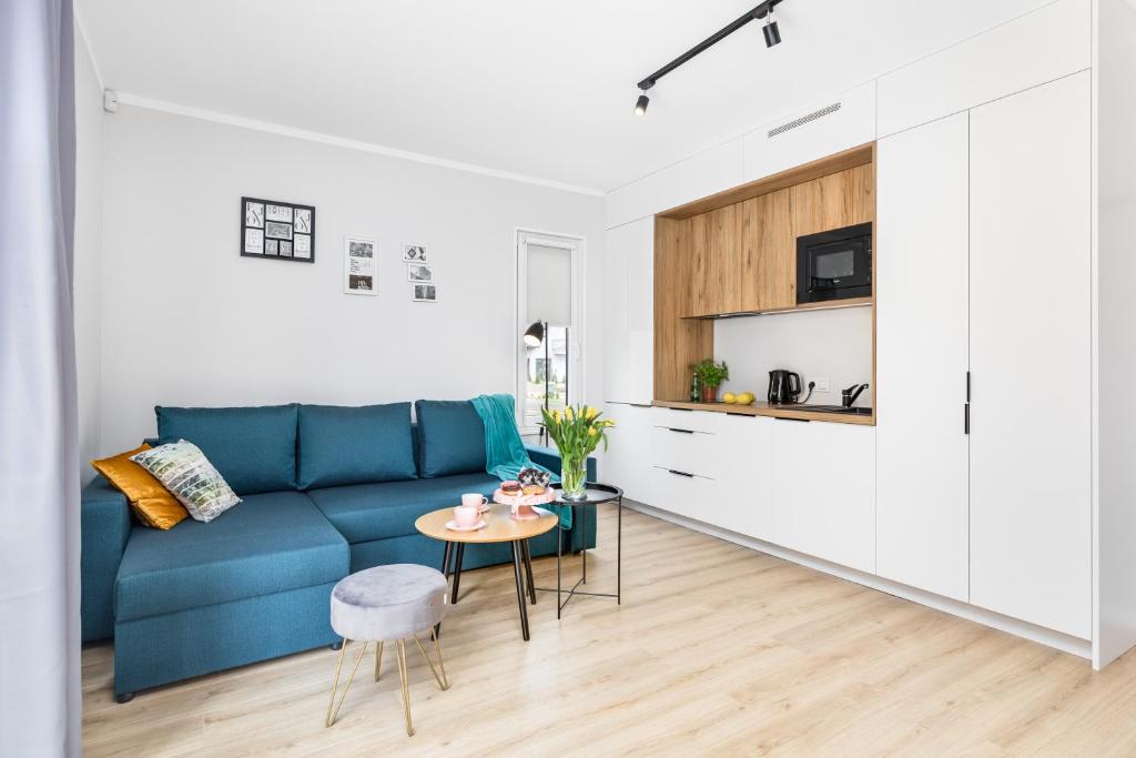 a living room with a blue couch and a table at Yellow House Dziwnów in Dziwnów