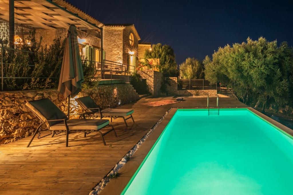 Skinária的住宿－Yiameli Villas with Private Pool，房屋旁的游泳池配有椅子和遮阳伞