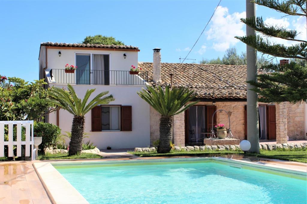 a villa with a swimming pool in front of a house at Villa Clara in Chiaramonte Gulfi