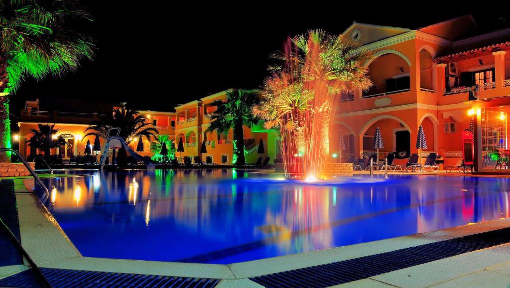 a swimming pool with a fountain in front of a building at LAGOON HOTEL & APARTMENTS in Sidari