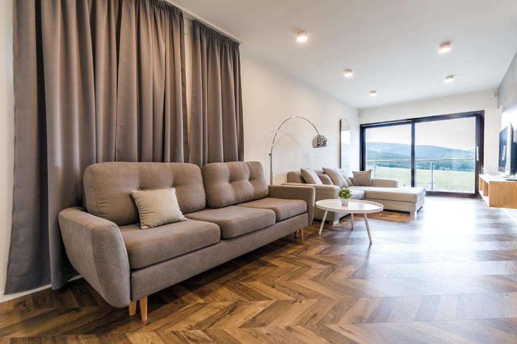 a living room with a couch and a table at Mountain view apartment in Loučná pod Klínovcem