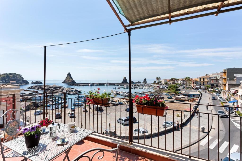 d'un balcon avec des tables et une vue sur le port. dans l'établissement La Finestra dei Ciclopi, à Aci Castello