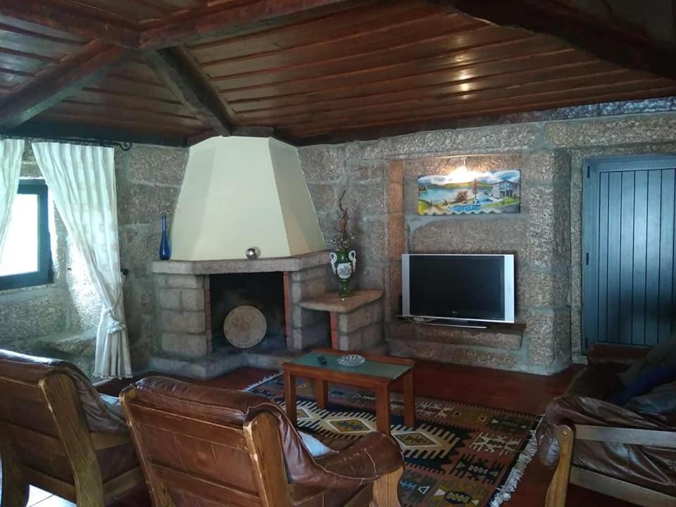 ヴィエイラ・ド・ミーニョにあるCasa Dos Gaiosのリビングルーム(暖炉、テレビ付)