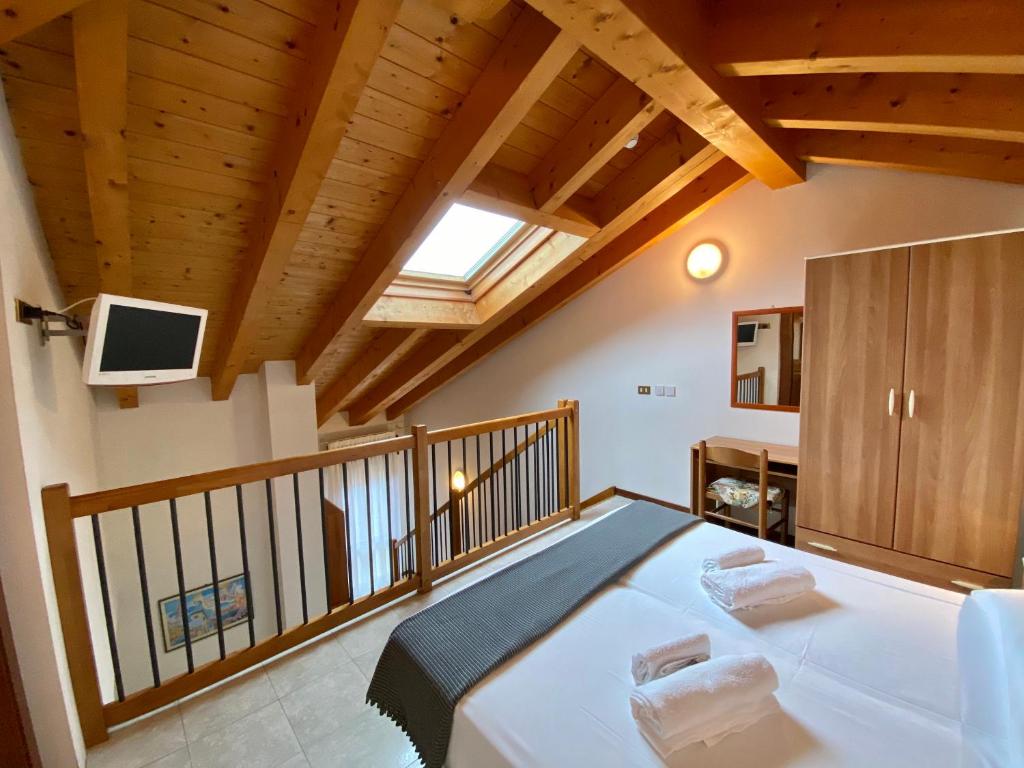 a bedroom with a large white bed with a balcony at Hotel Rosa Caorle in Caorle