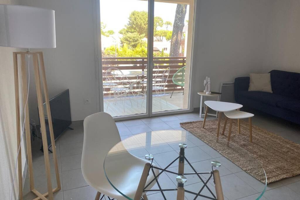 a living room with a glass table and a couch at Superbe apt proche plage et centre ville in Saint-Georges-de-Didonne