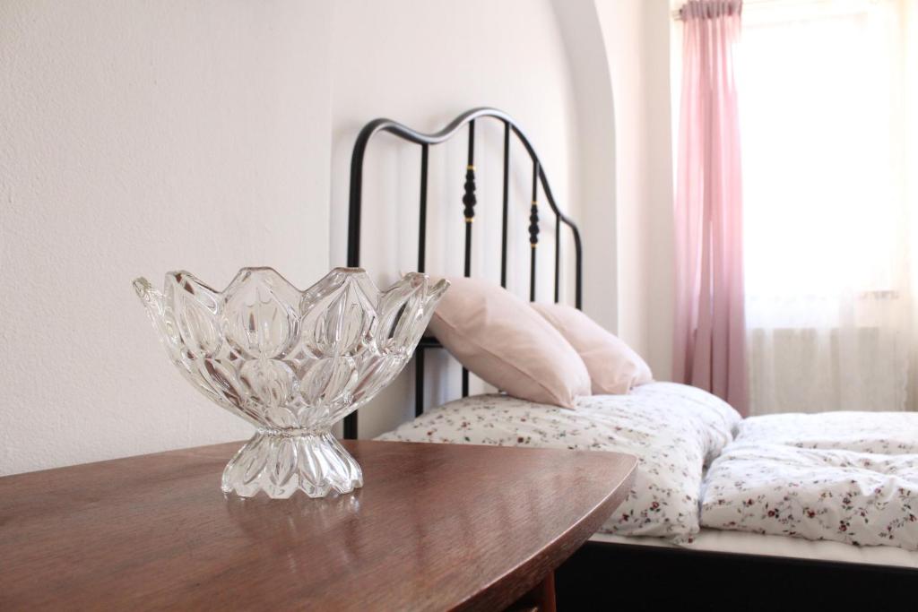 un vaso di vetro seduto su un tavolo accanto a un letto di Schrott Bed&Beer a Brno