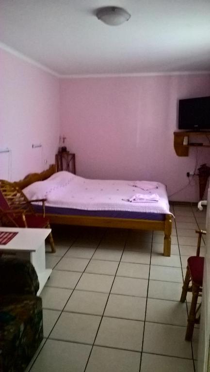 Bett in einem Zimmer mit lila Wänden in der Unterkunft Sobe Rooms Szobák Zimmer KIS in Palić