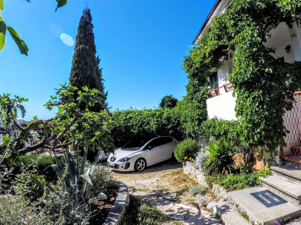 un coche aparcado frente a una casa en Apartment Gašparević, en Rogoznica