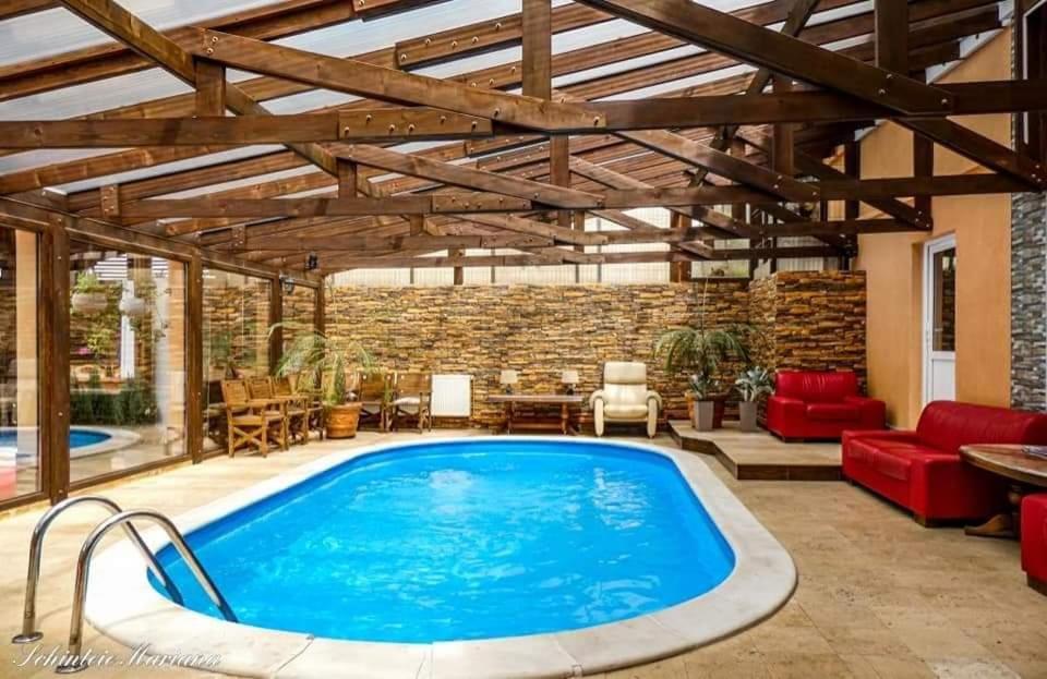 a swimming pool in a patio with a brick wall at Casa Piri in Anina